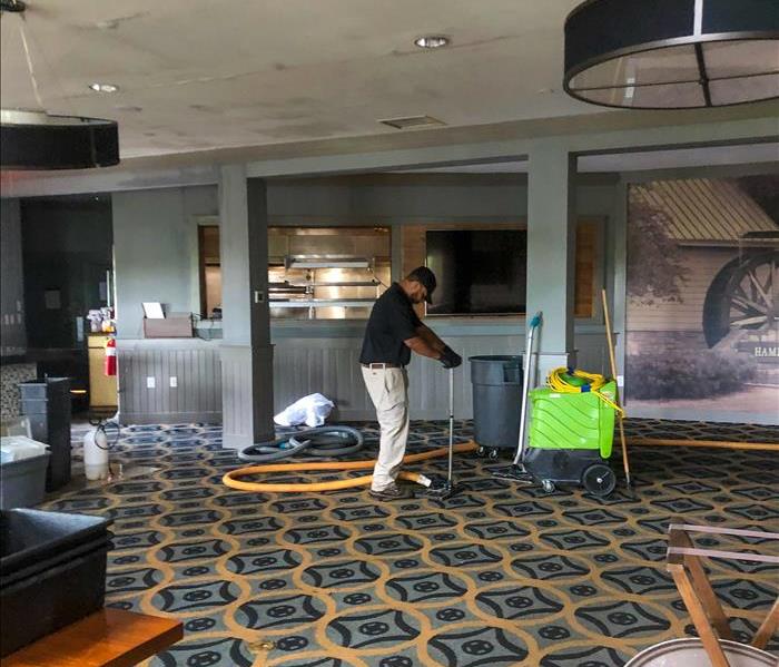 SERVPRO tech removing water from the floor of a business in Acworth, GA.